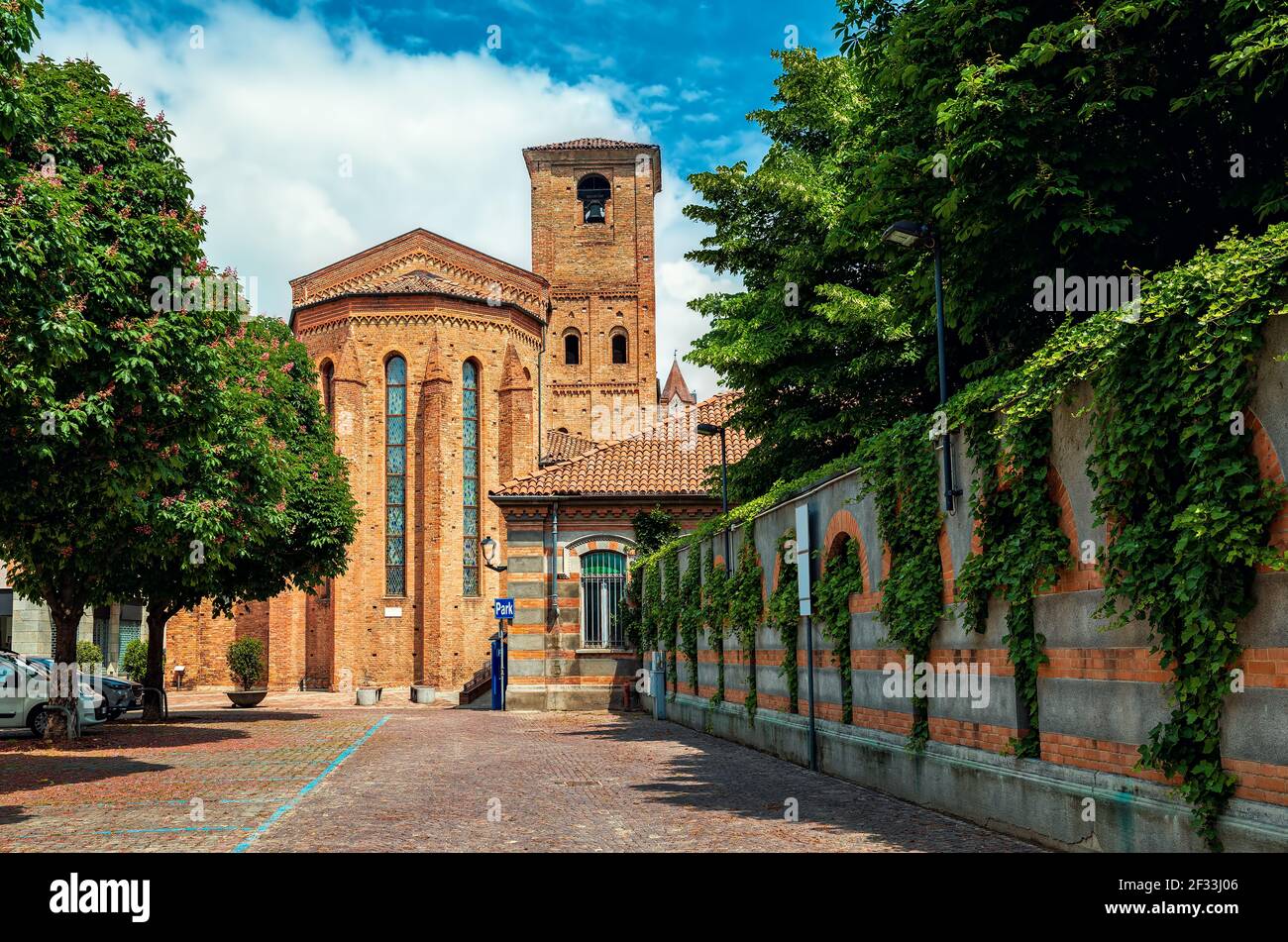 Vista de la calle adoquinada y la iglesia católica de ladrillo en el casco antiguo de Alba, Piamonte, norte de Italia. Foto de stock