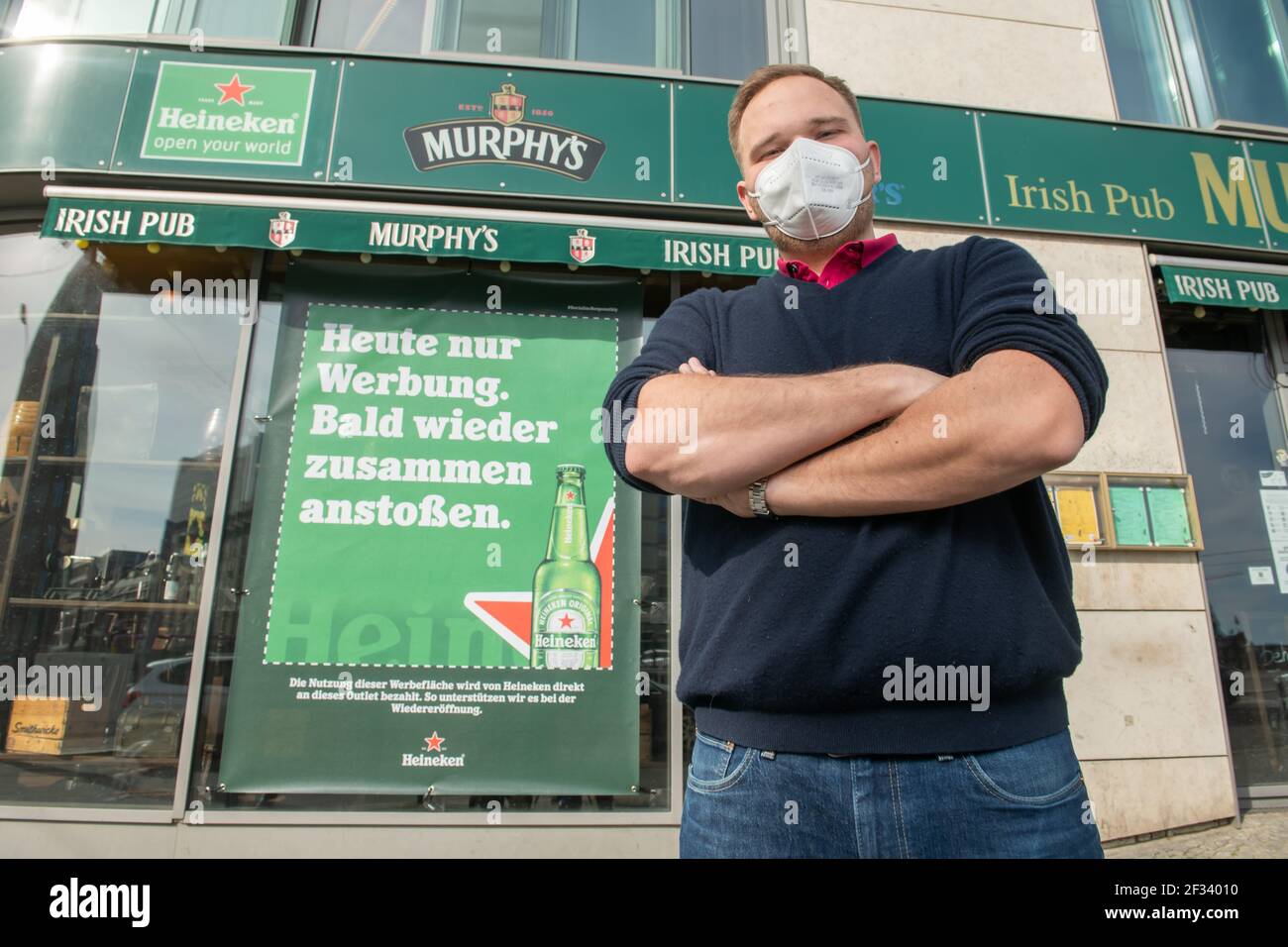 Berlín, Alemania. 09th de marzo de 2021. El director gerente Till Haffner  está frente al bar cerrado Murphy's Irish Pub en Berlín con un mensaje  publicitario de la Marca Heineken. Con la