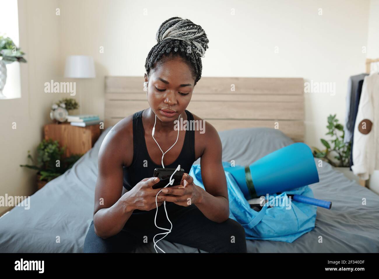 Young beautiful slim fit woman in activewear resting at yoga class