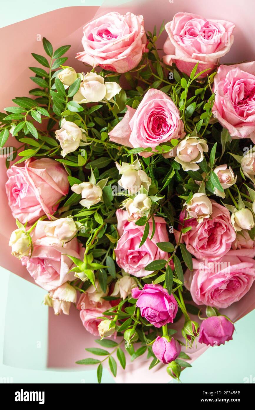 Día de la madre, día de la mujer o concepto de saludos de cumpleaños.  Hermoso ramo de flores rosas rosas rosas y flores de primavera sobre un  fondo verde Fotografía de stock -