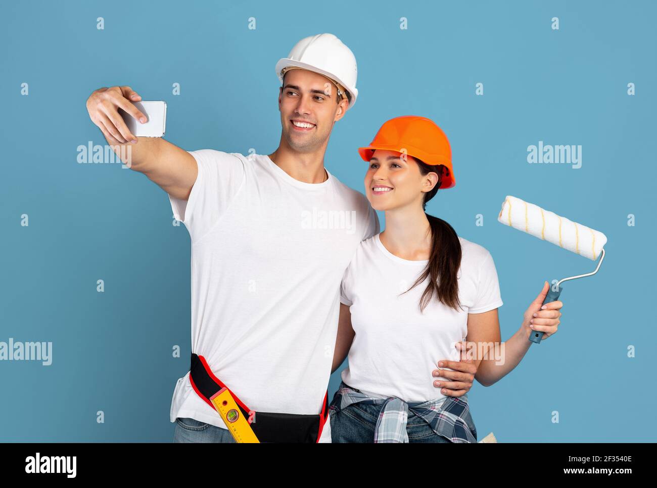 congelado Optimismo Banco Joven hombre y mujer en sombreros duros tomando Selfie en el smartphone  Durante la reparación Fotografía de stock - Alamy