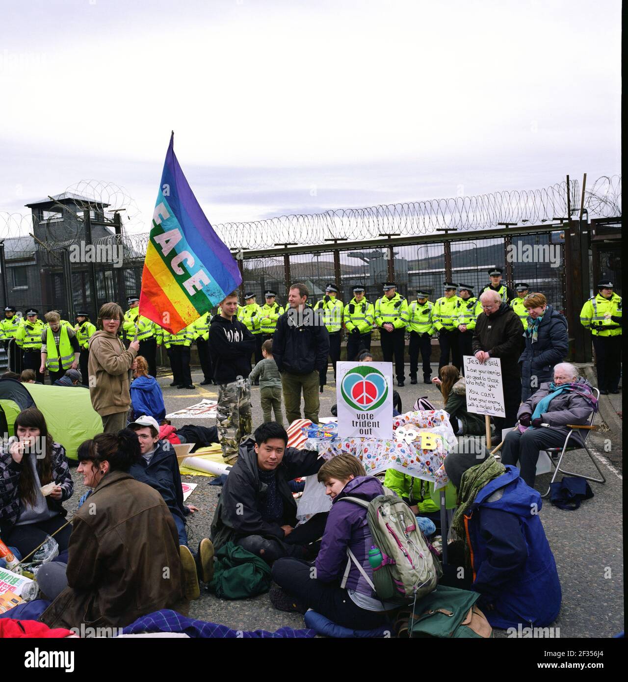 Los manifestantes se sentaron fuera de la base Naval de su Majestad en Faslane, en Gare Loch, Argyll y Bute, en la costa oeste de Escocia. La instalación, es una de las tres bases operativas en el Reino Unido para la Marina Real y es su sede en Escocia. Es más conocido como el hogar de las armas nucleares británicas, en la forma de submarinos nucleares armados con misiles Trident y es también el sitio del campo de la Paz de Faslane. Foto de stock