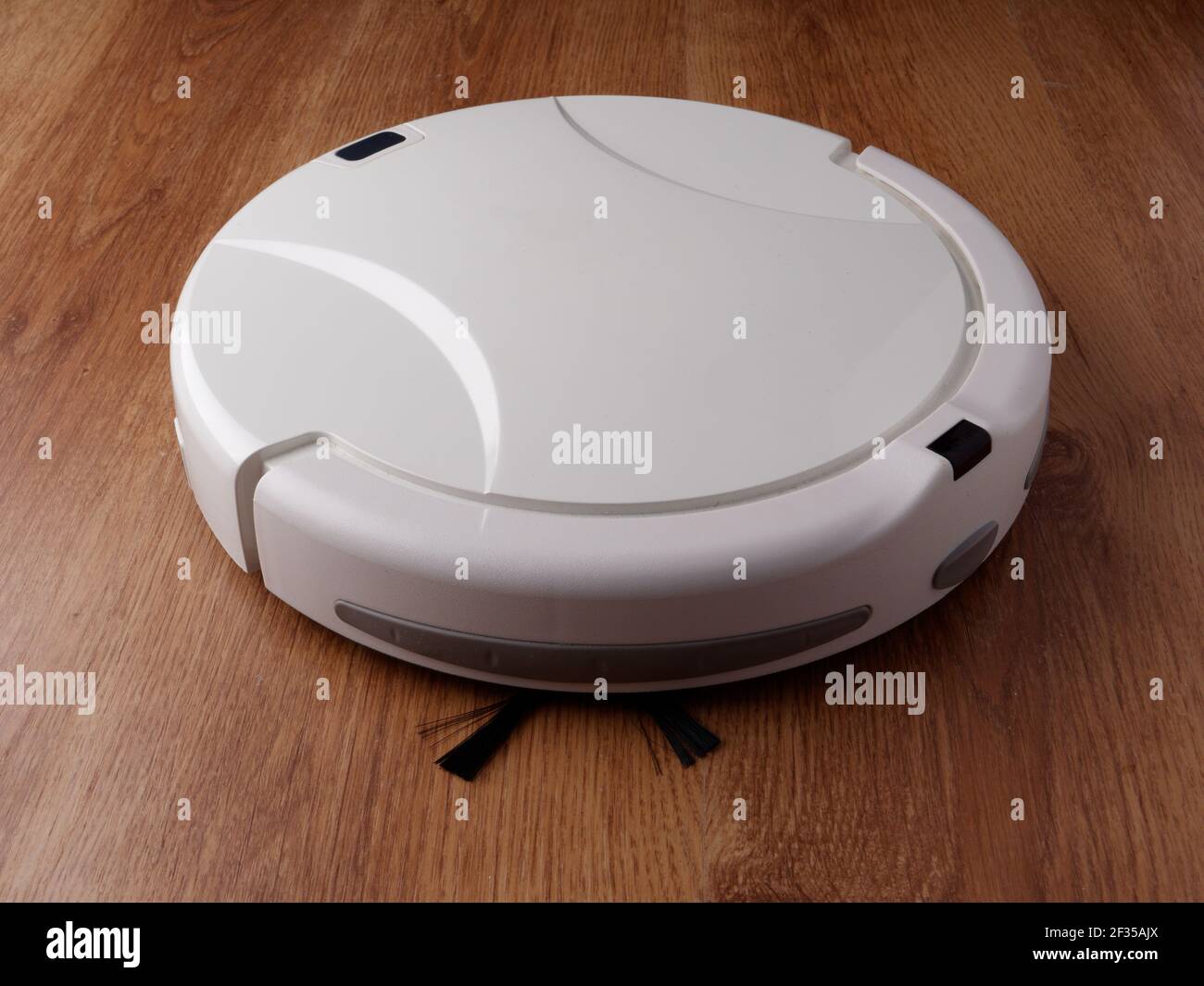 Robot aspirador se apoya en un suelo de parquet de madera, el concepto de  limpieza en la casa, la automatización de la limpieza Fotografía de stock -  Alamy