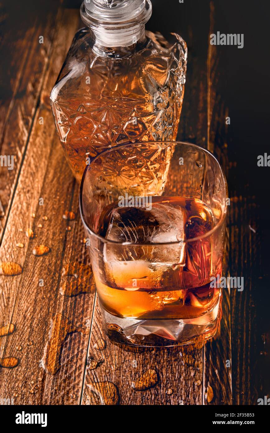 Toma superior de un vaso y una botella de whisky en una mesa de madera con  varias salpicaduras. Día internacional del whisky Fotografía de stock -  Alamy