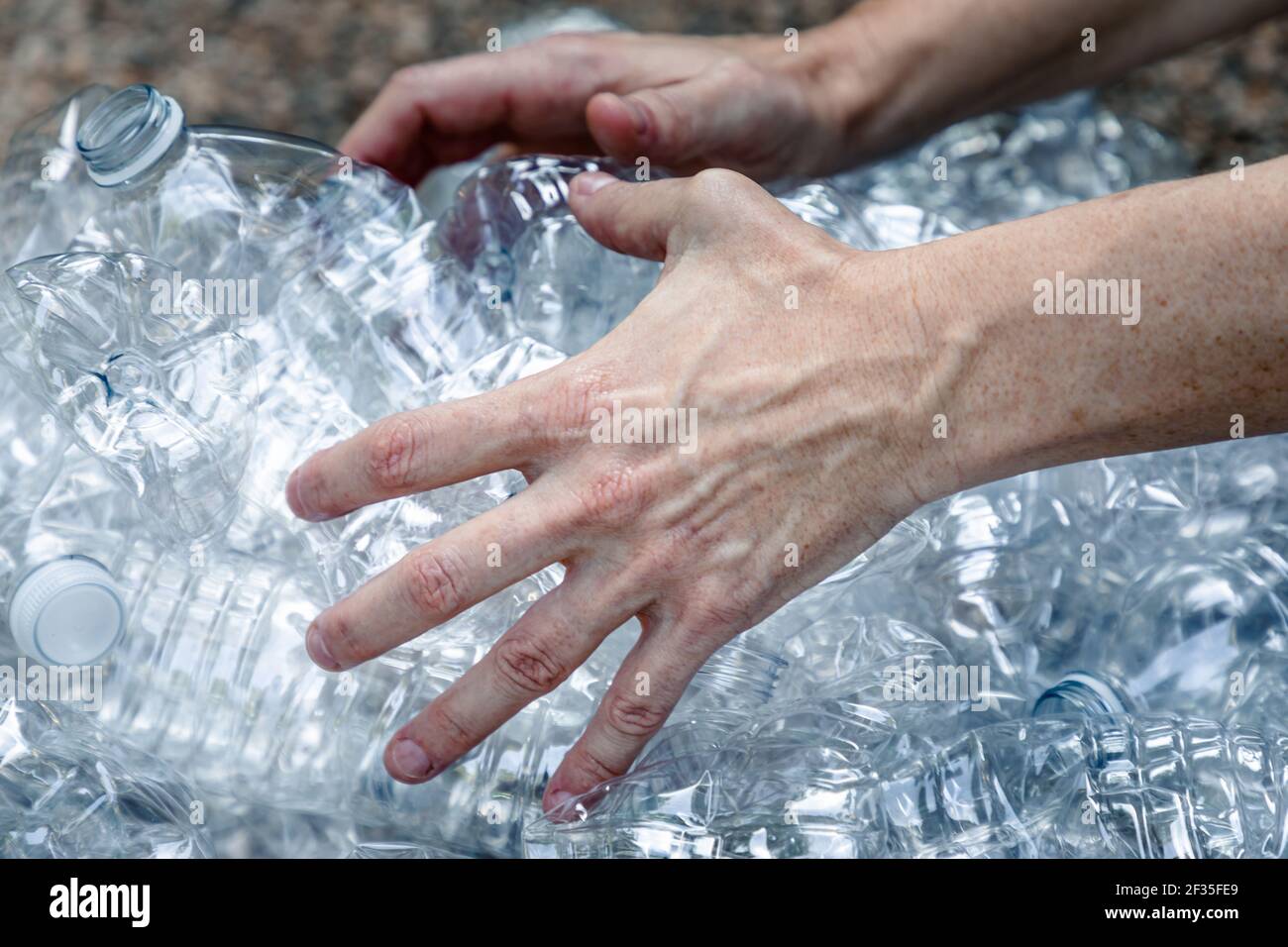 Femals manos agarrando botellas de plástico para recogerlas y desecharlas Foto de stock