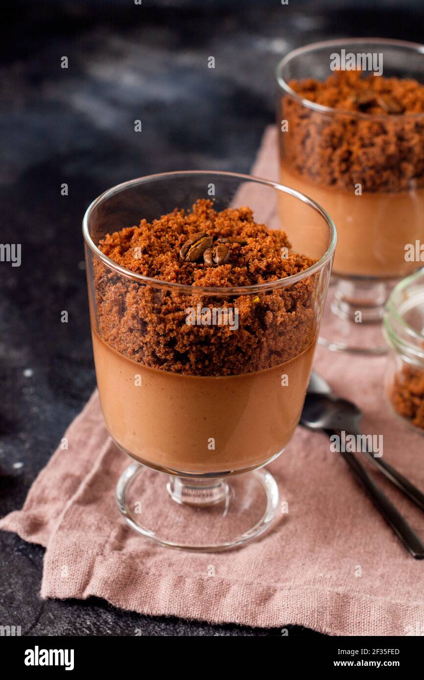 Mousse de chocolate con brownie en tarros de vidrio sobre un fondo oscuro de pizarra, piedra o hormigón. Postre delicioso. Enfoque selectivo. Foto de stock