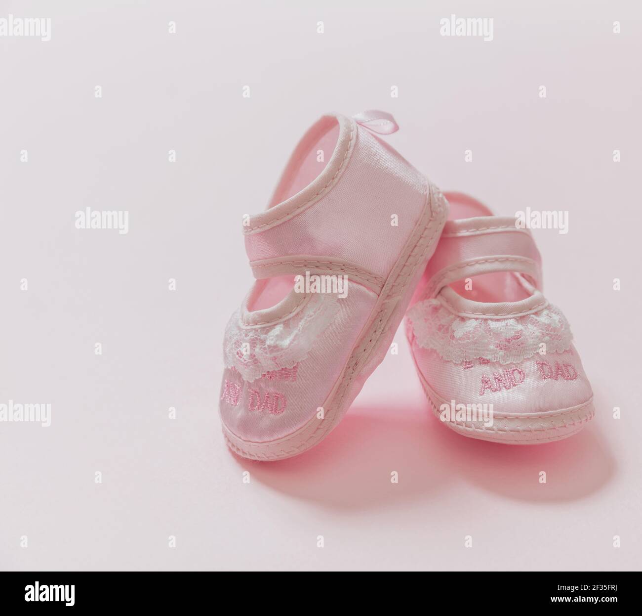 Bebé niña zapatos de color rosa sobre fondo de color rosa. Ducha de bebé, concepto de bautizo. Es una plantilla de anuncio de recién nacido Bebé mujer suave footwea Fotografía de