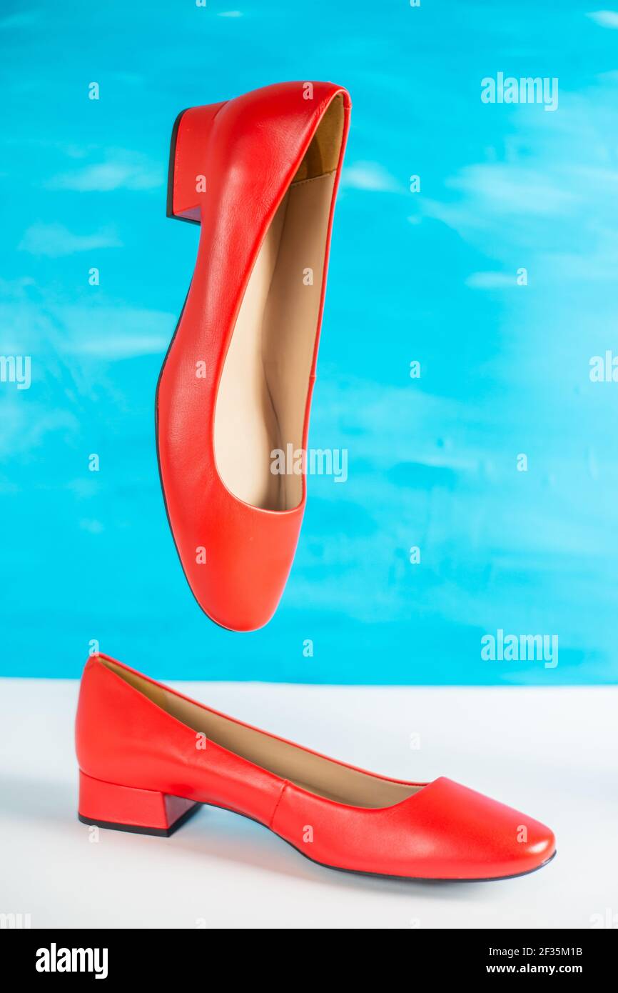 zapatos rojos brillantes suspendidos con azul Fotografía de stock -
