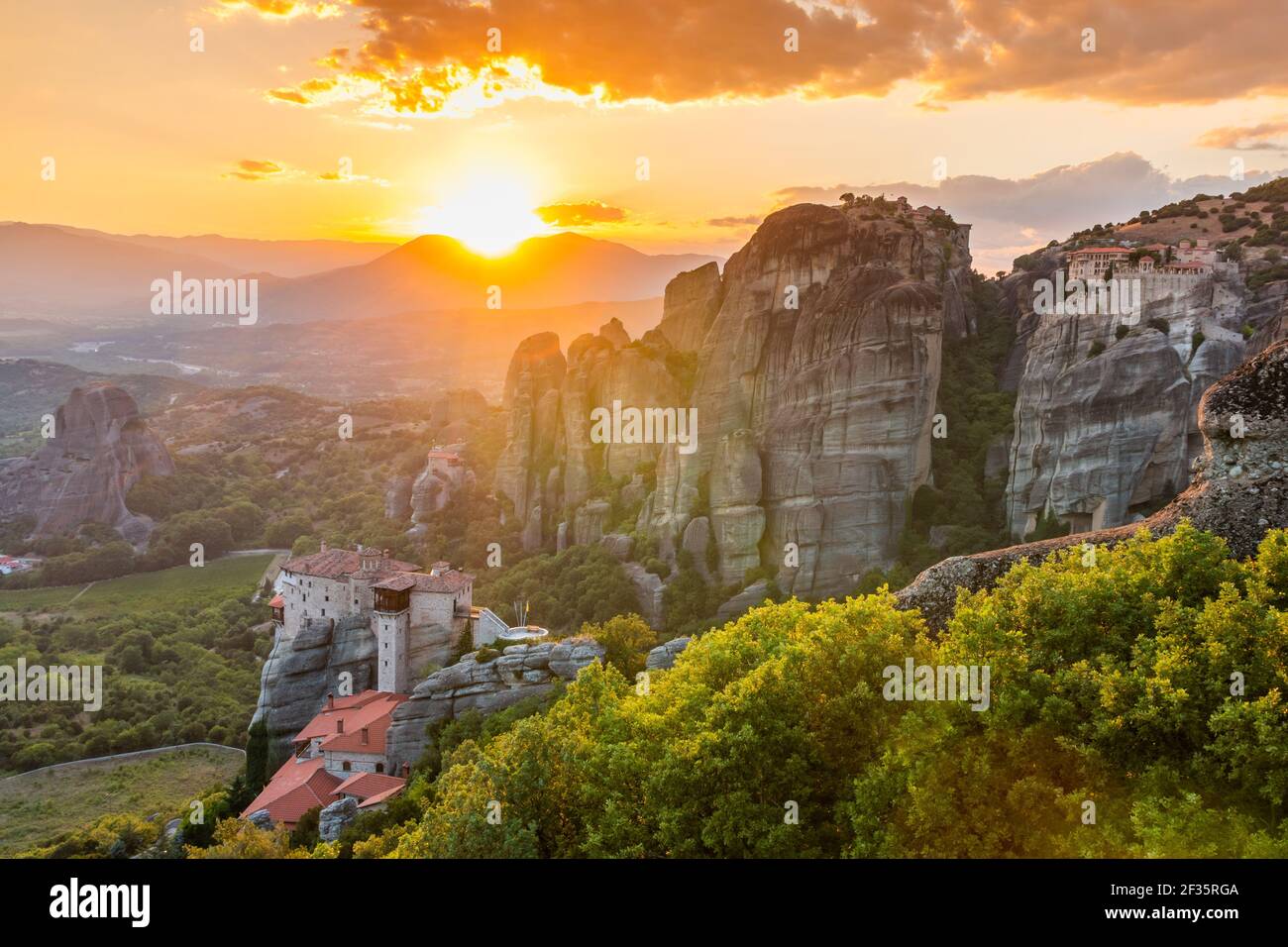 Meteora, Grecia. Formaciones rocosas de arenisca, los monasterios de Rousanou y Nikolaos al atardecer. Foto de stock