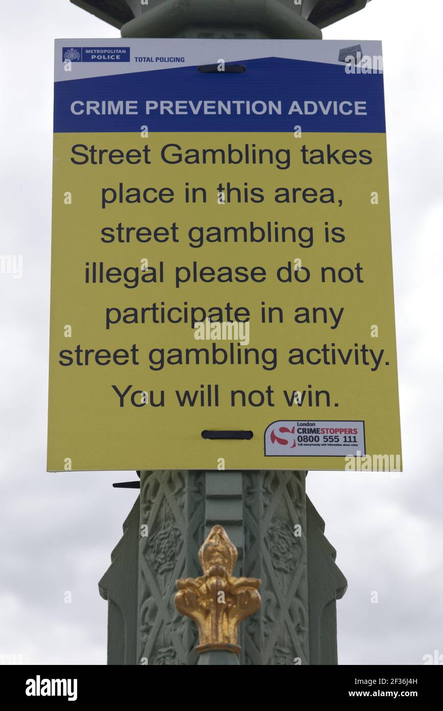 póster de consejos de prevención de delitos, advirtiendo al público de juegos ilegales de azar en la calle Foto de stock