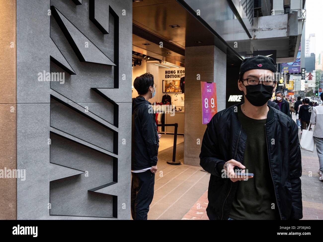 Un peatón que lleva una máscara pasa por delante de la Marca multinacional  estadounidense de ropa deportiva, Nike Store y su logotipo en Hong Kong  Fotografía de stock - Alamy