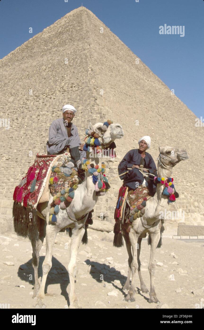 Egipto El Cairo El distrito egipcio de Giza Gran Pirámide de Kheops, construido 2600 a.C. Siete Maravillas del Mundo, hombres musulmanes jinetes de camellos que ofrecen paseos, Foto de stock