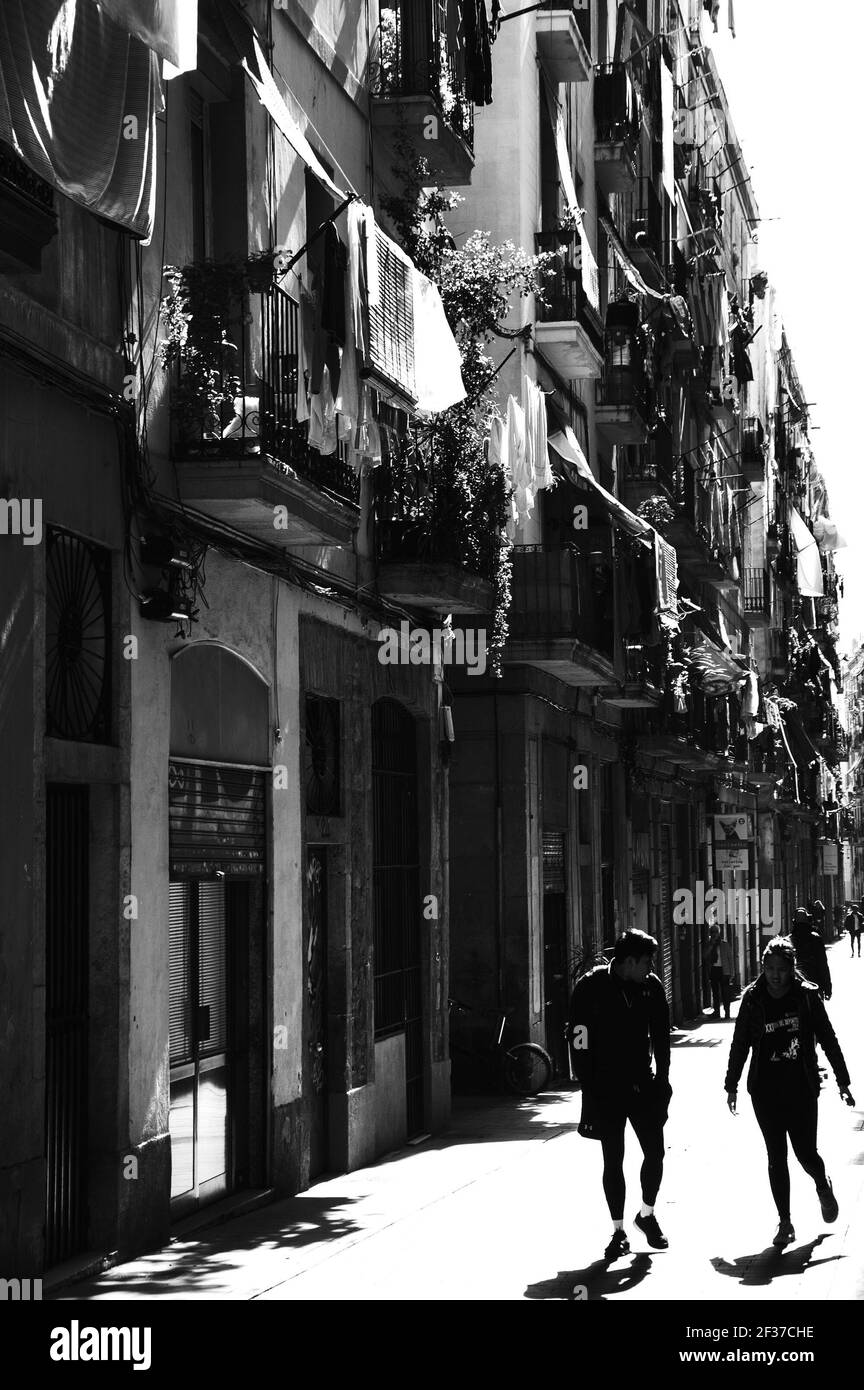 BARCELONA, ESPAÑA - 10 DE MARZO de 2018: Escena urbana de Barcelona. Jovencito y mujer jogging en la con secante en los balcones la ciudad vieja Fotografía de stock - Alamy