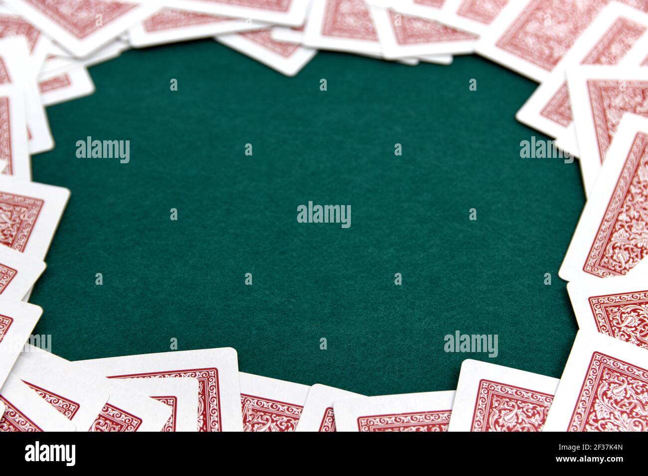 Imagen de una mesa verde para juegos de cartas, rodeada por los bordes con  las cartas de una baraja, dejando el centro libre para agregar texto o  gráficos (espacio de copia Fotografía