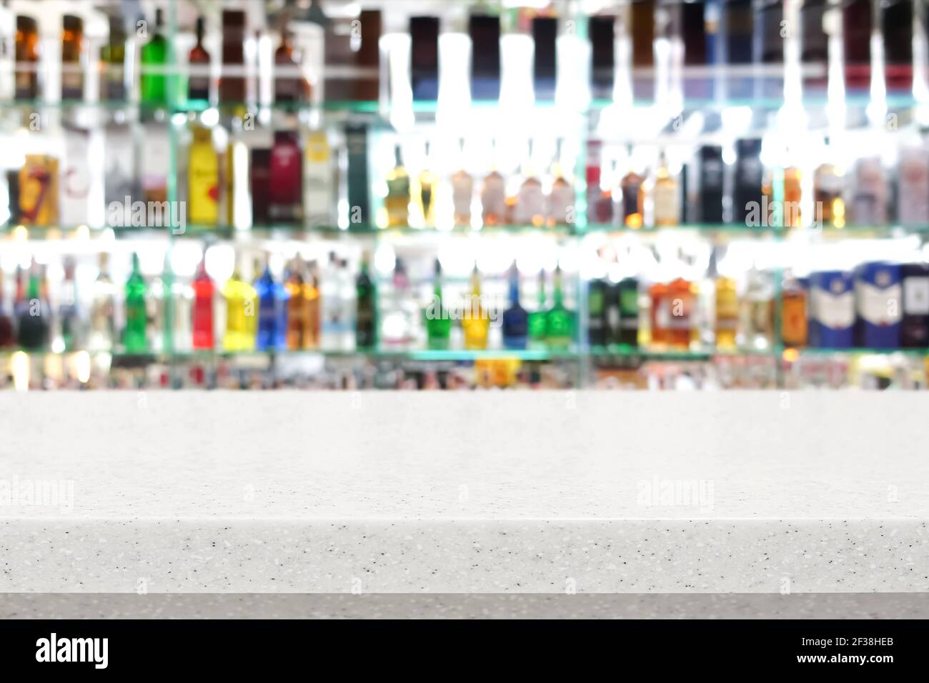 Barra de piedra blanca en la parte superior de borroso colorido botella de alcohol antecedentes Foto de stock