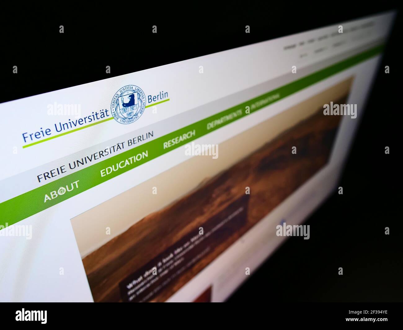 Vista de gran angular de la página web con el logotipo de la institución educativa alemana Freie Universität Berlin (FU) en el monitor. Enfoque en la parte superior izquierda de la pantalla. Foto de stock