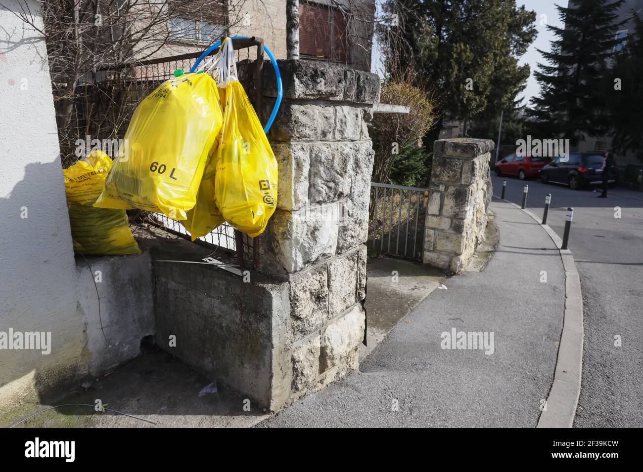 Bolsas de plástico amarillo colgadas en la entrada de la casa. La ciudad de  Zagreb recicla para que los ciudadanos recogen plástico en bolsas amarillas  y a la vez Fotografía de stock -