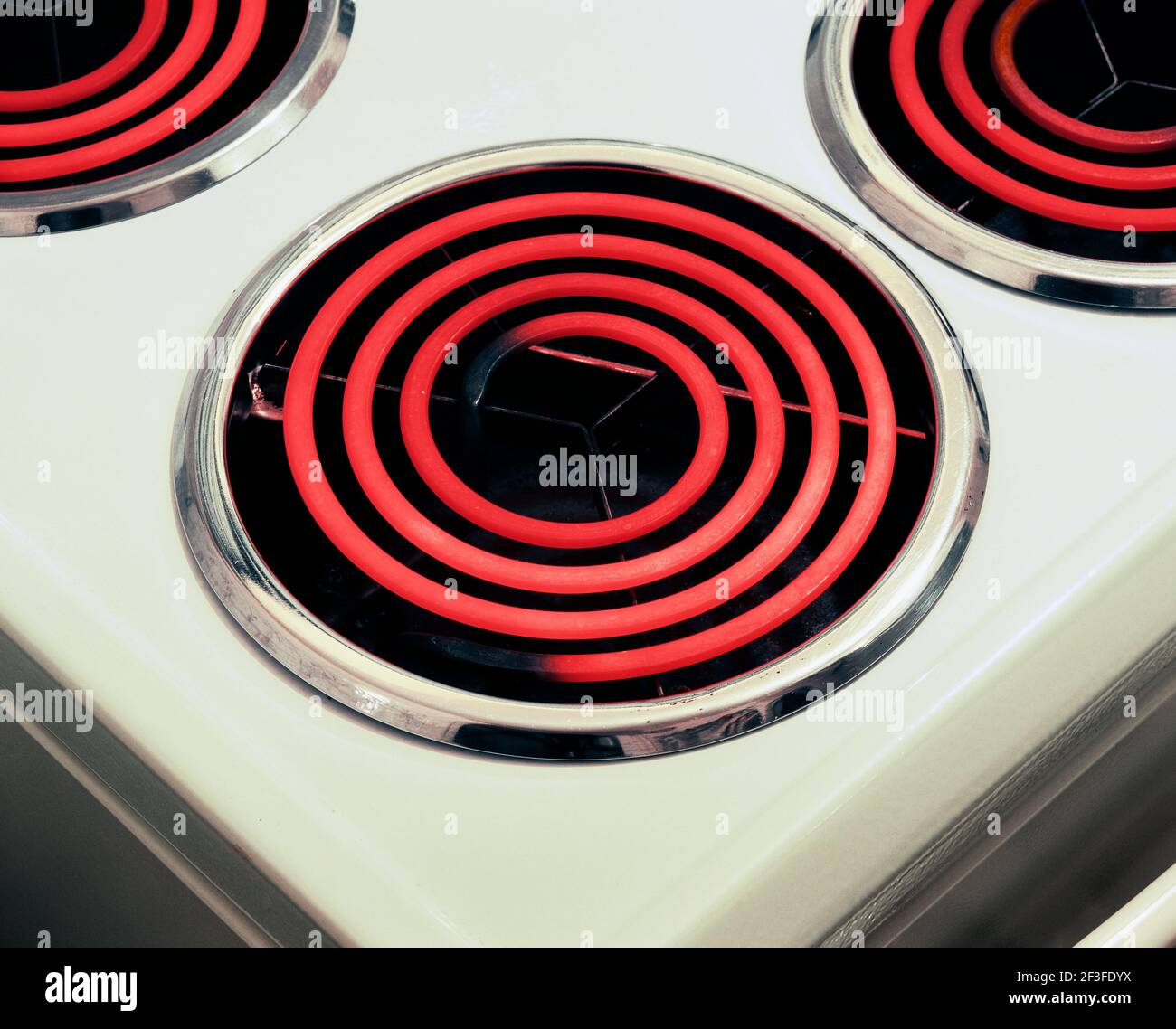Primer plano de estufa eléctrica con anillos calientes rojos brillantes. Foto de stock