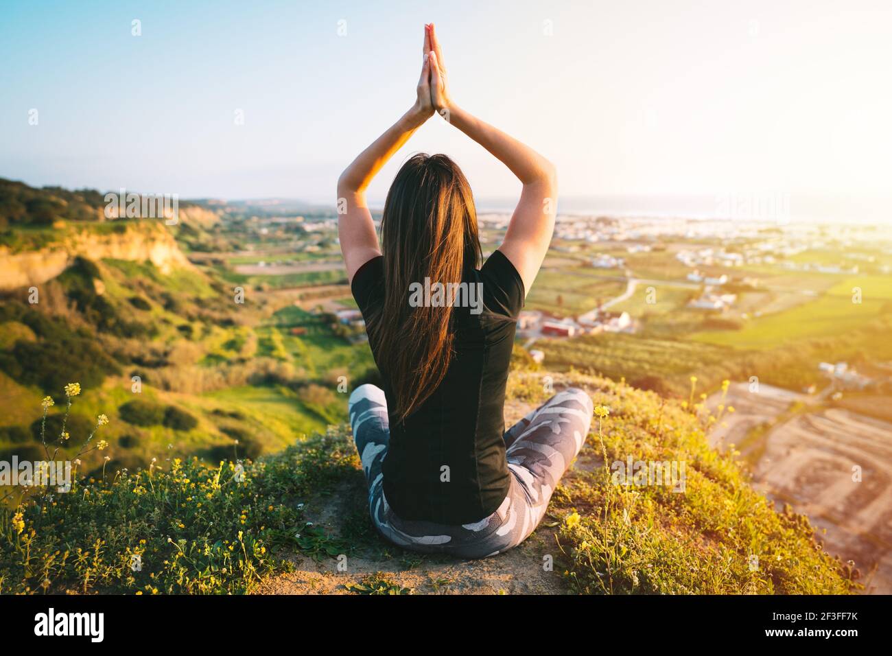 Mujer Caucásica Joven Que Hace Yoga En La Montaña, Vestido Con Ropa  Deportiva Blanca. Ella Relajarse Y Meditar En La Parte Superior De La  Cumbre En La Estera De Yoga. Kazajstán, Almaty