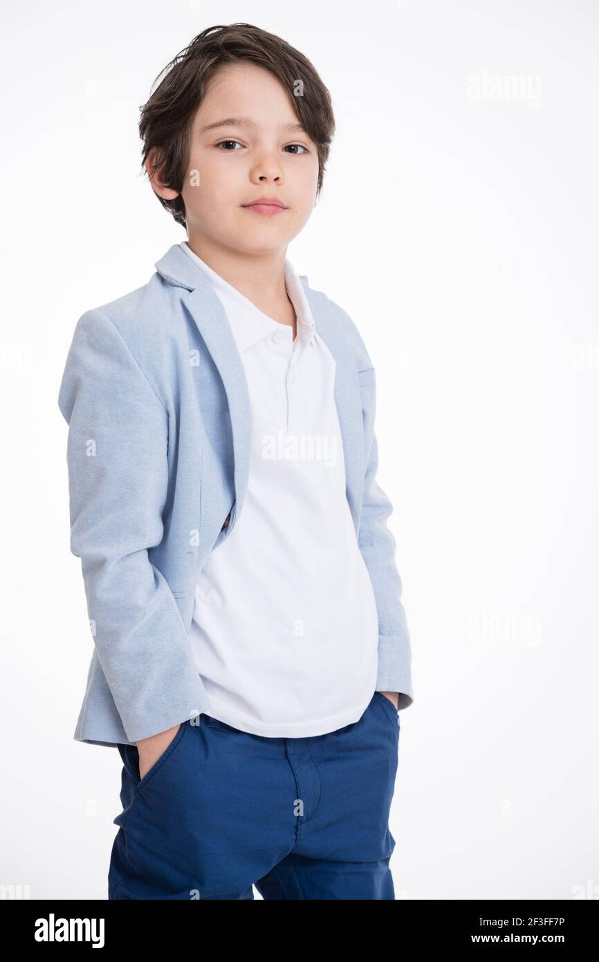 Joven niño feliz en traje posando sobre fondo blanco Foto de stock