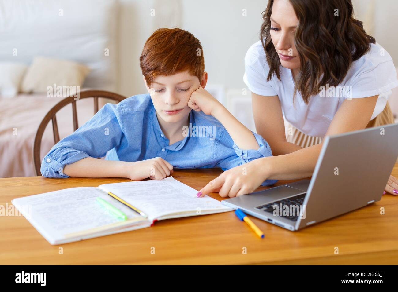 La foto de una mamá ayuda a su hijo con la tarea en línea. Concepto de