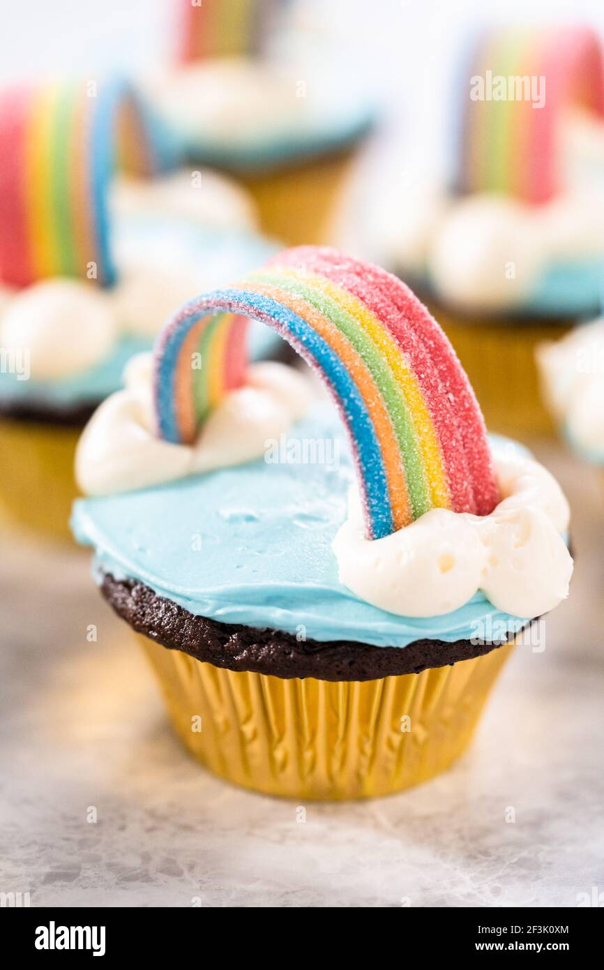 Cupcakes de chocolate decorados con helado de crema azul y arco iris para  una fiesta de cumpleaños temática unicornio Fotografía de stock - Alamy