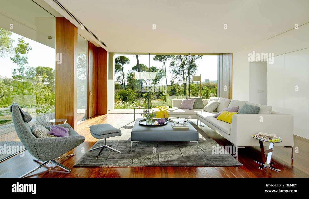 Muebles de color gris en el salón diáfano de la moderna casa residencial en Sifera, España Foto de stock