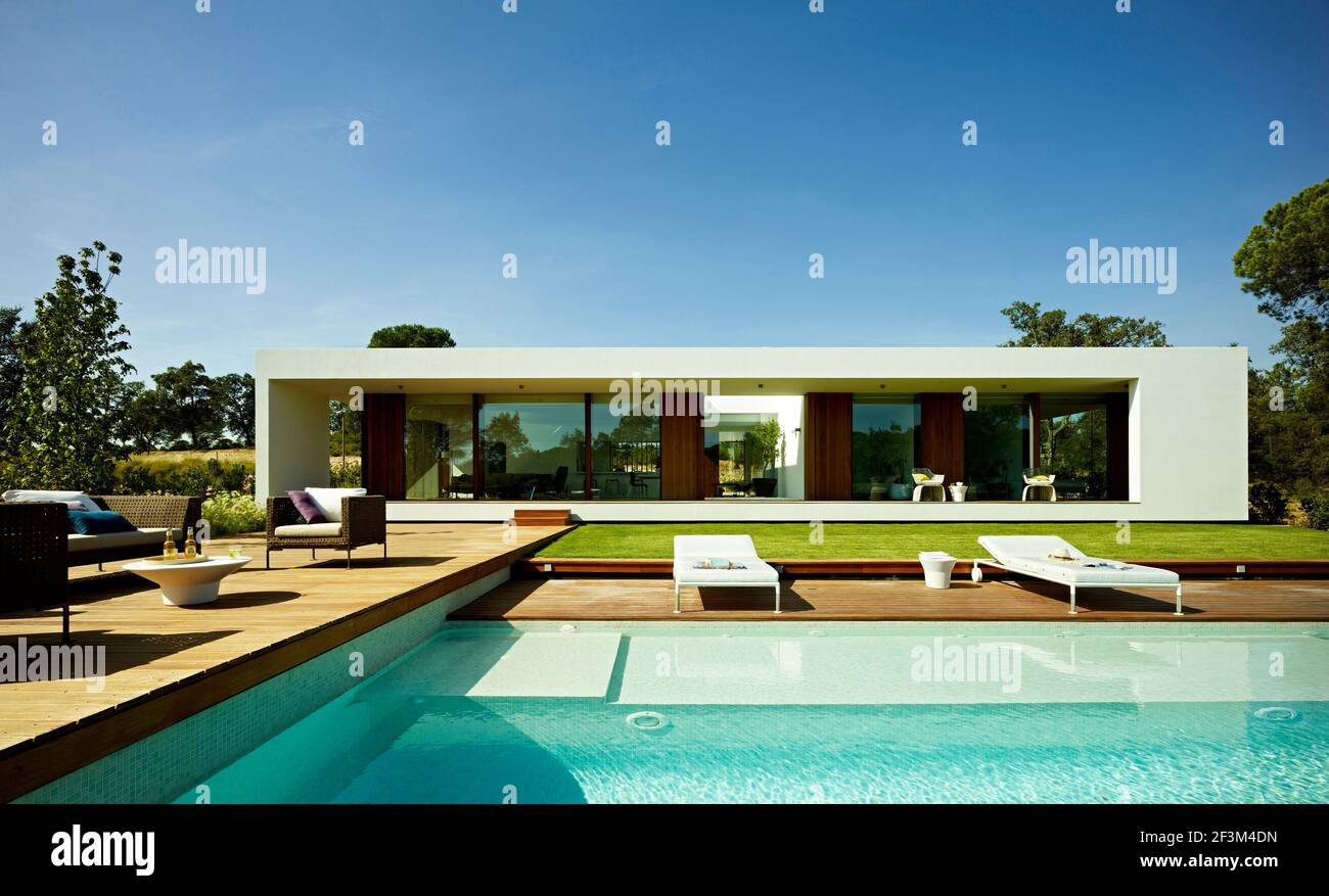 Tumbonas junto a la piscina de la moderna casa residencial en Sifera, España Foto de stock