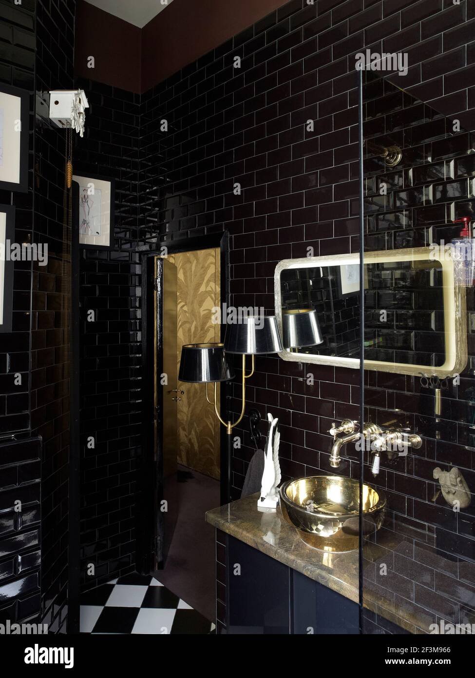 Baño de ladrillo negro y dorado con espejo y lámpara en casa residencial  francesa Fotografía de stock - Alamy