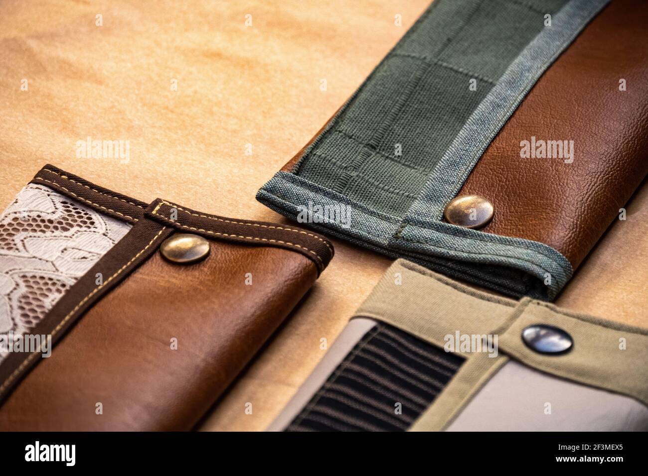 Carteras hechas a de cuero y tela, con remaches metálicos, sobre mesa de madera. moda Fotografía stock - Alamy