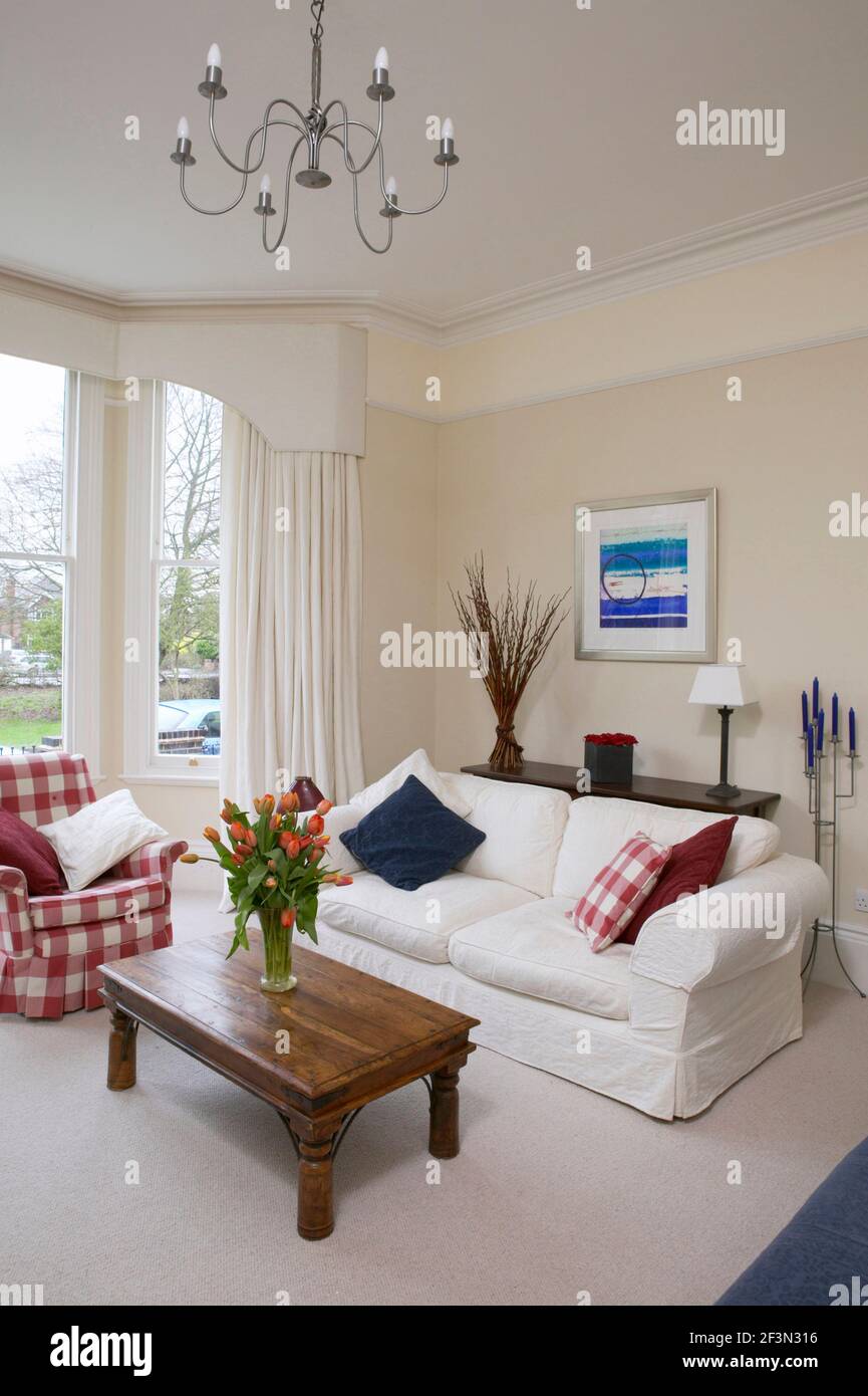 sala de estar con mesa de café, sofá blanco con cojines y jarrón con  tulipanes Fotografía de stock - Alamy