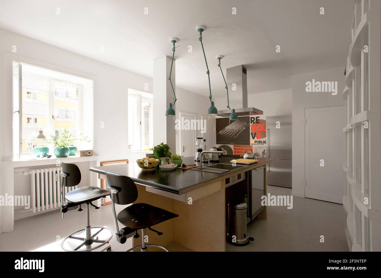 El Modernismo en el 'Cake House'. Una cocina minimalista con lámparas que cuelgan del techo. Foto de stock
