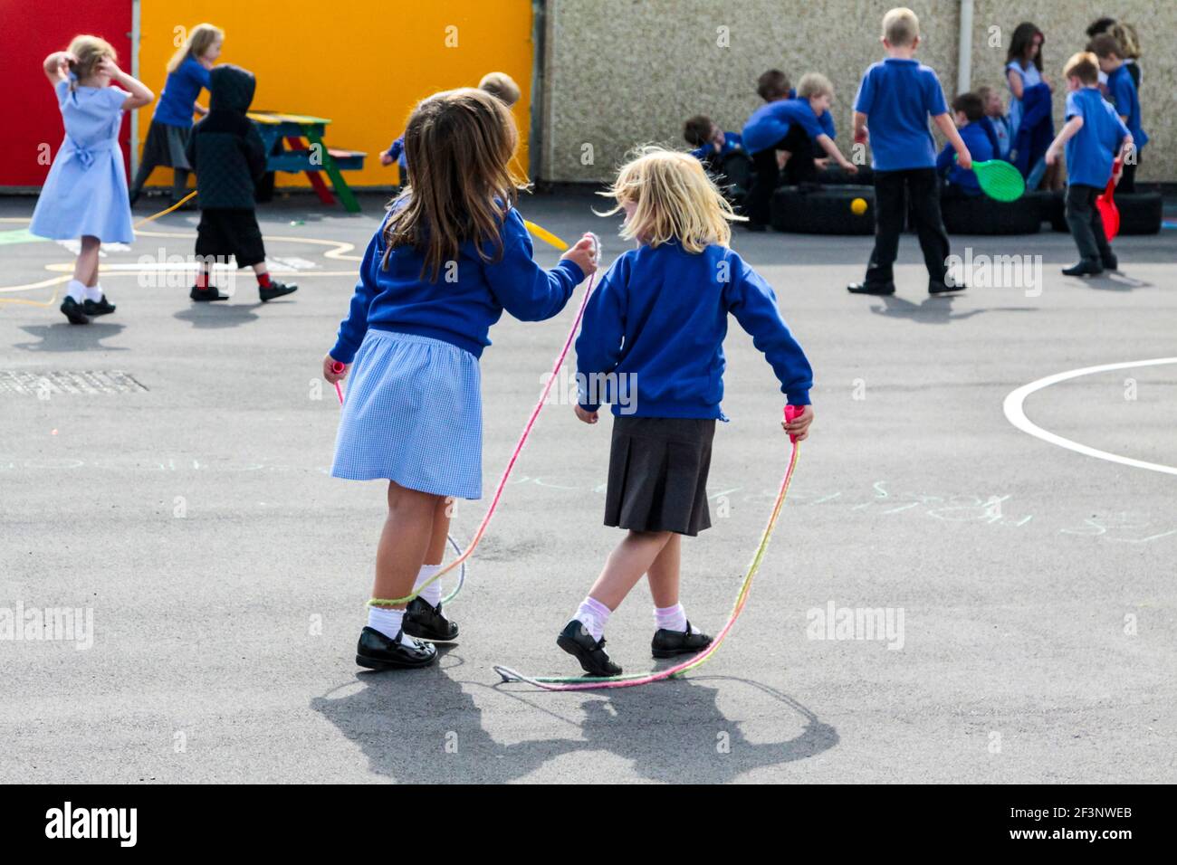 Escolares de primaria jugando en un patio de recreo escolar en un descanso entre clases