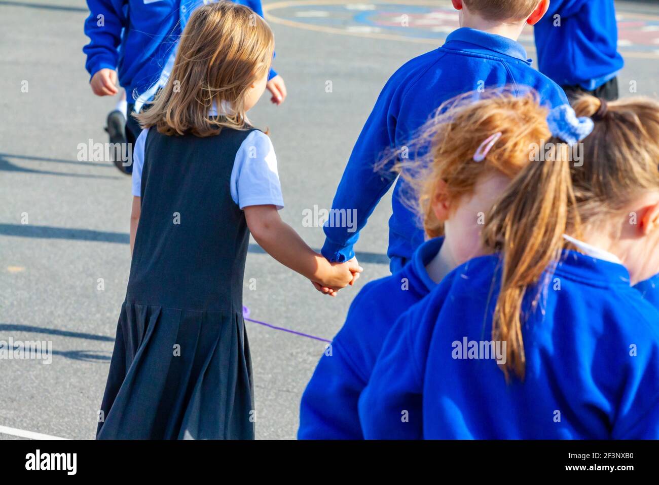 Escolares de primaria jugando en un patio de recreo escolar en un descanso entre clases