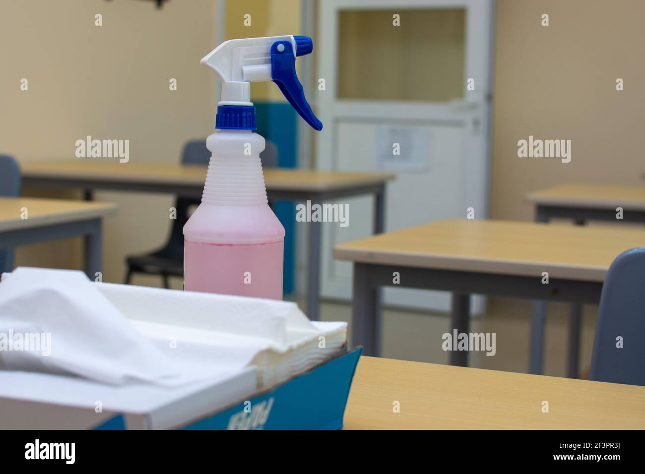 Una botella de aerosol y toallas de papel en una oficina o mesa escolar  para conceptos de limpieza y desinfección para conceptos de COVID-19  (coronavirus Fotografía de stock - Alamy