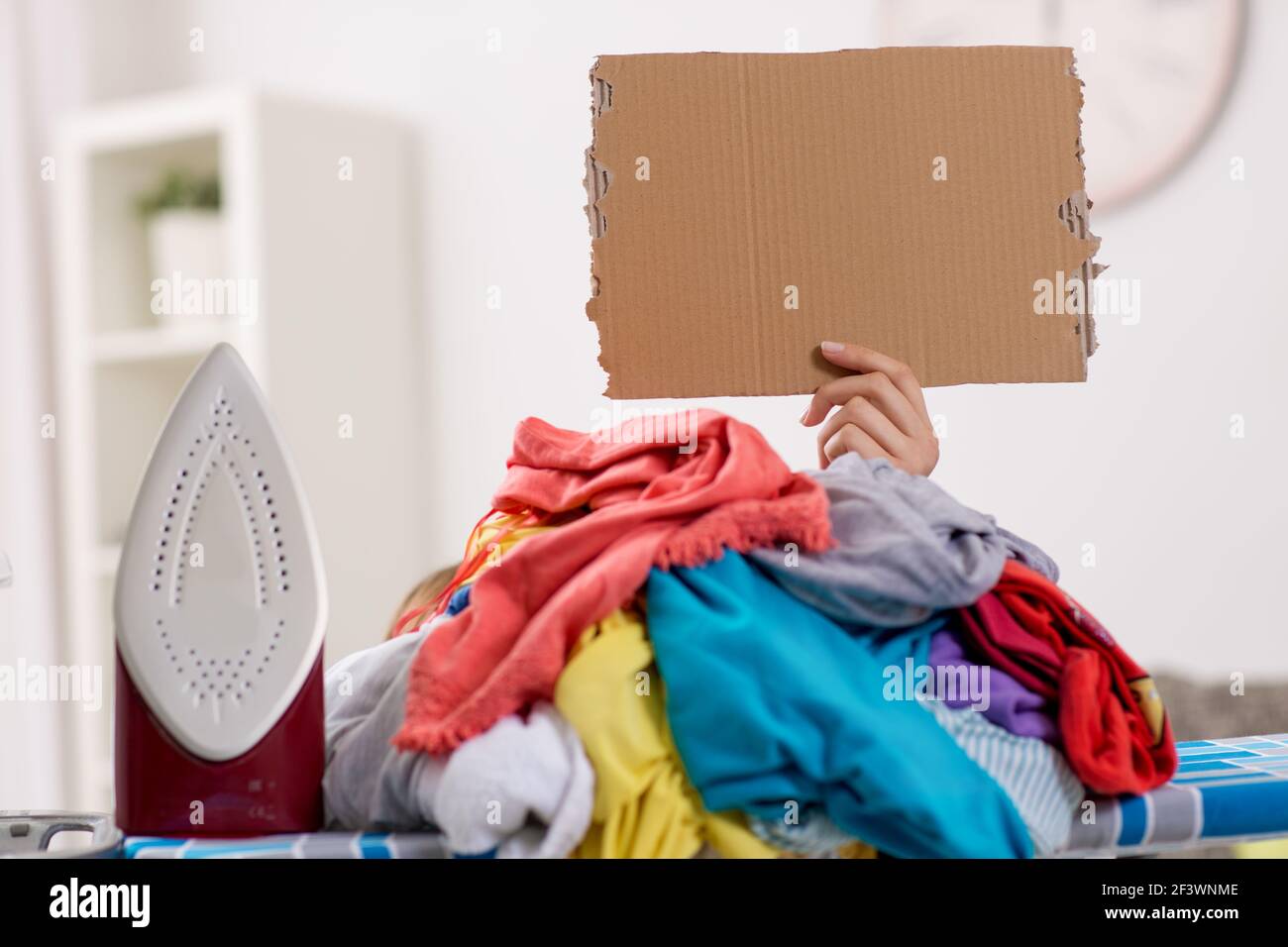 que plancha necesita escondida por una gran pila de ropa Fotografía de stock - Alamy