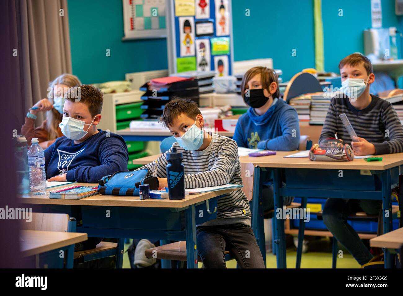 La ilustración muestra a los niños que llevan una máscara bucal en clase, en la escuela primaria de Valke en Lichtervelde, jueves 18 de marzo de 2021. Como el número o Foto de stock