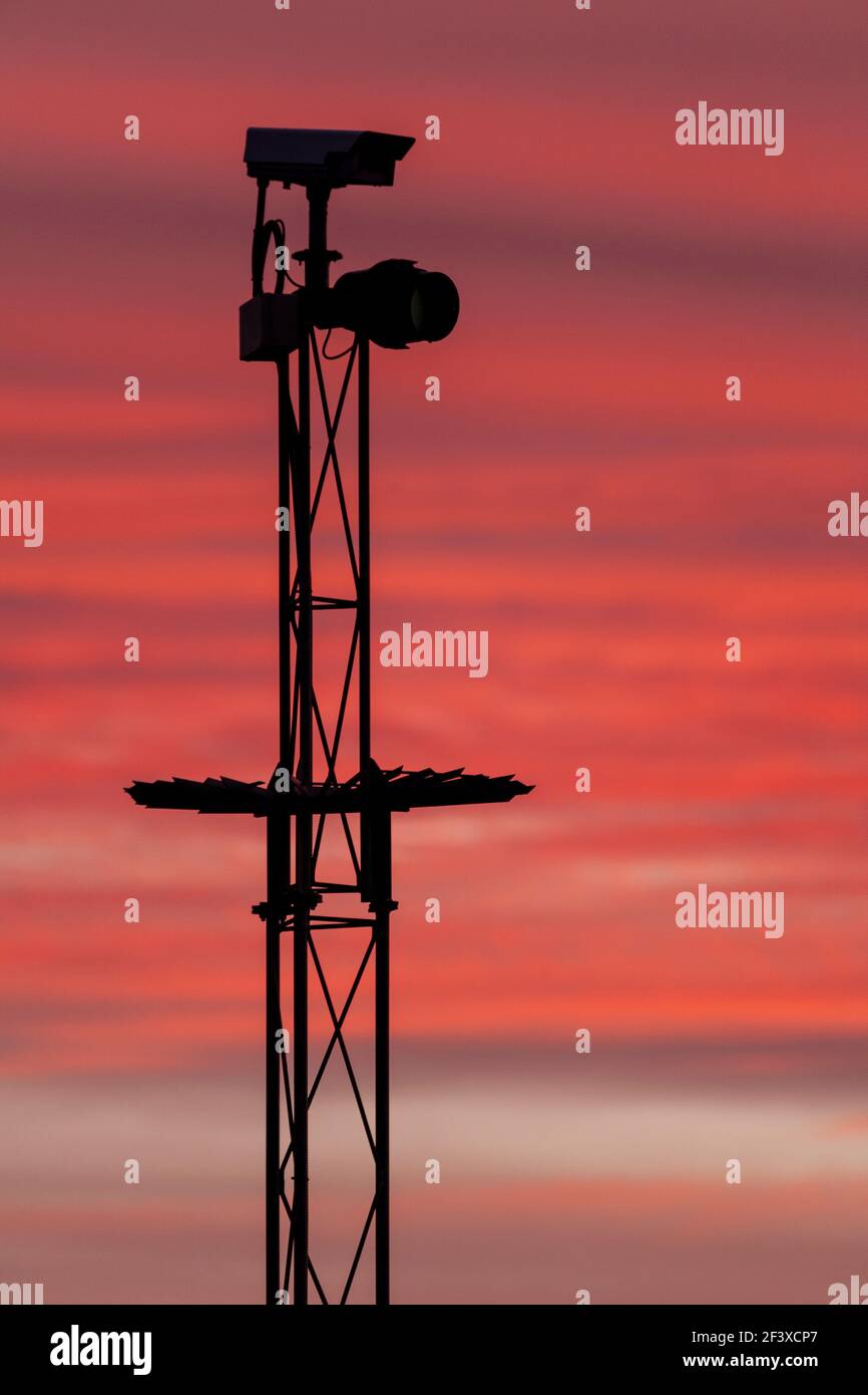 Cámara de seguridad en silueta contra un cielo rosa Foto de stock