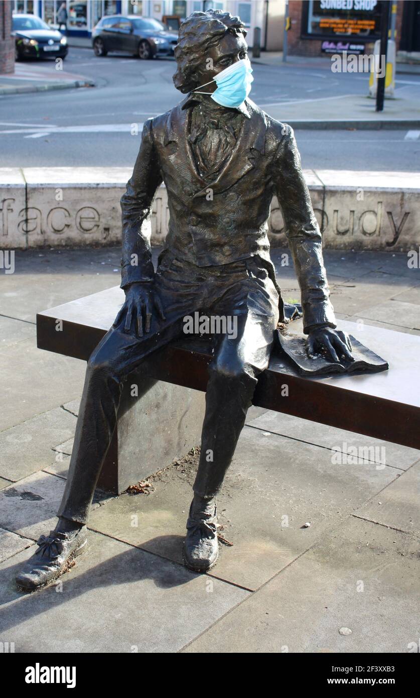 John Keats estatua en Chichester sobre la cual alguien ha pegado una máscara. Foto de stock