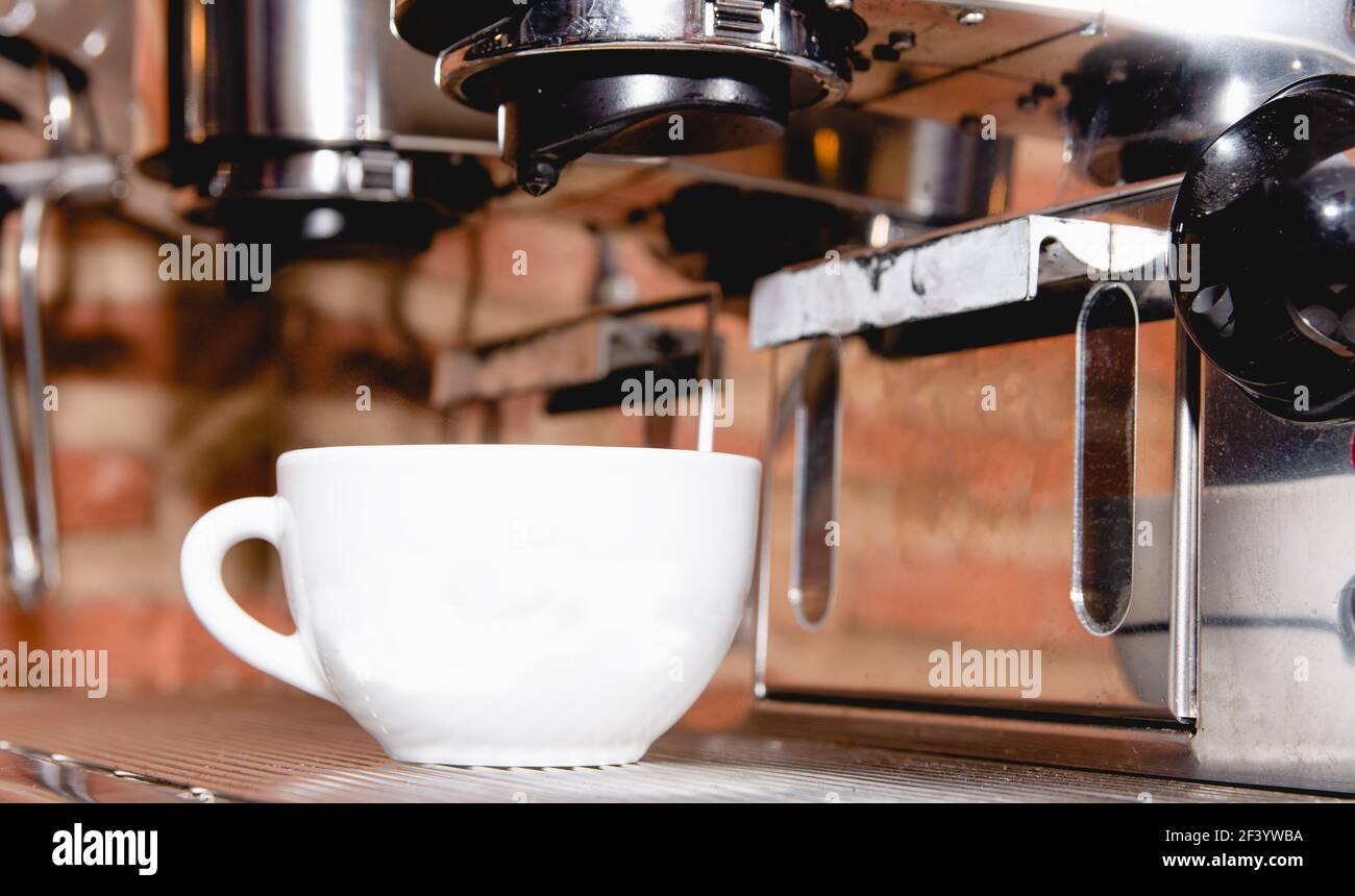 Máquina de café espresso italiano en el mostrador de un restaurante que  ofrece recién hecho café en una taza pequeña Fotografía de stock - Alamy