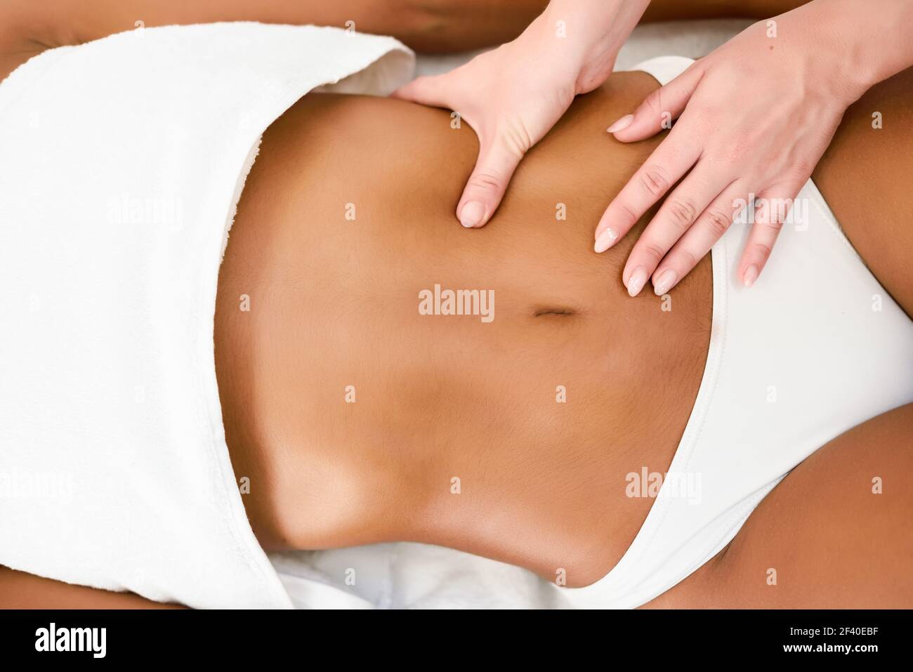 Mujer recibiendo masajes de abdomen en Spa wellness center. Belleza y conceptos estéticos. Foto de stock