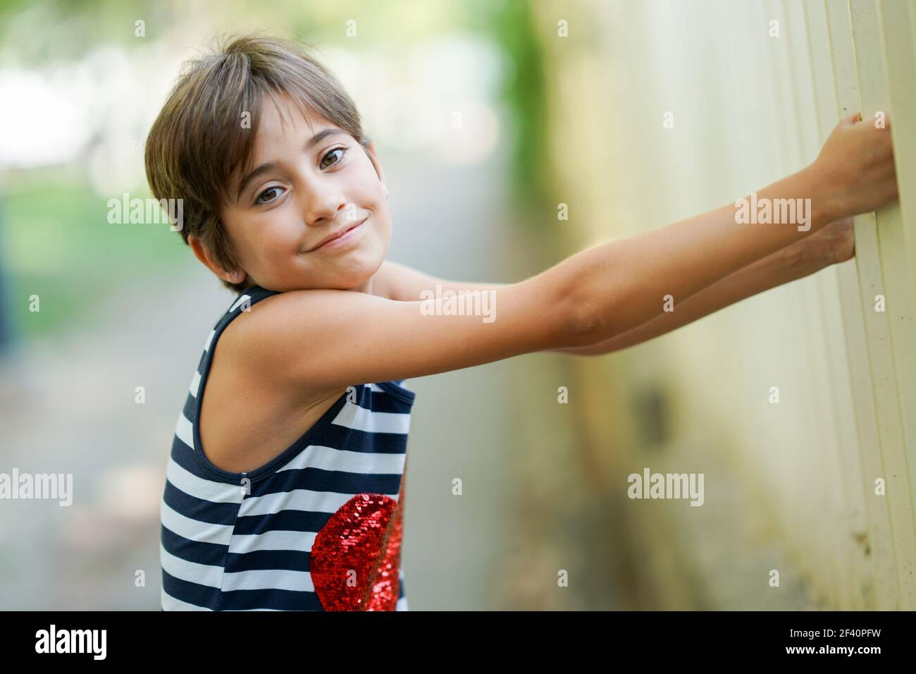 Niña pequeña, de ocho años, divirtiéndose en un parque urbano. Niña pequeña, de ocho años, divertirse al aire libre. Foto de stock