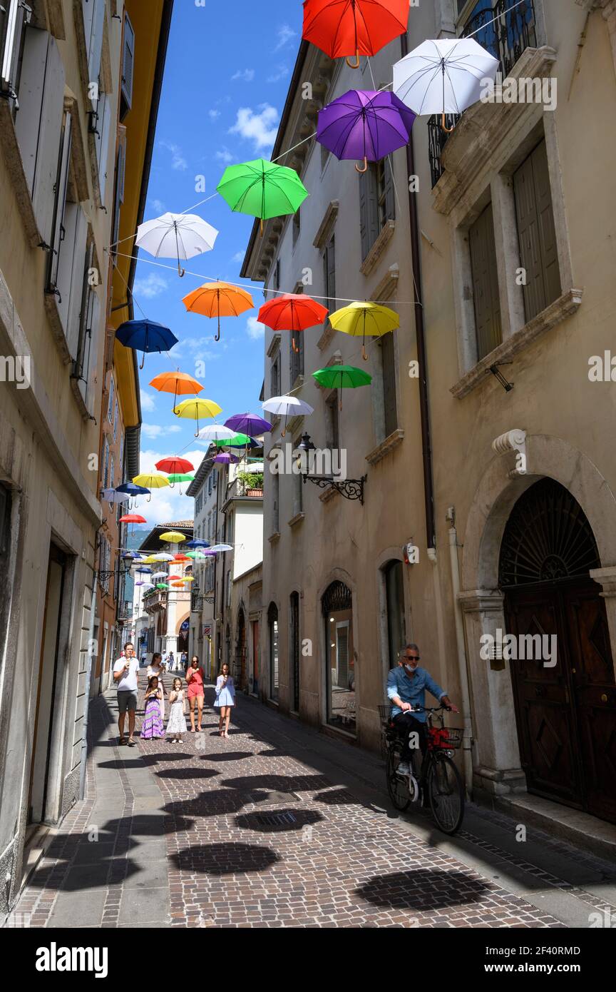 Rovereto. Italia. Coloridos paraguas en Via Orefici en el centro histórico de la ciudad. Foto de stock