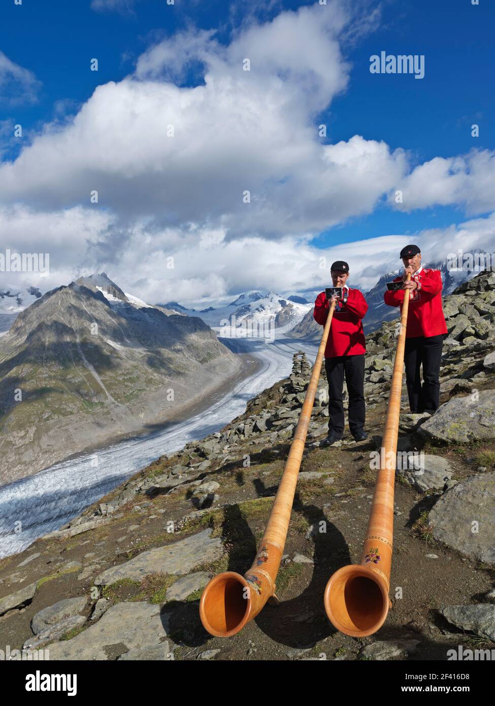Suiza, la región de Goms, Aletsch, el glaciar Aletsch con dos músicos suizos tocando el instrumento de música alpenhorn Foto de stock