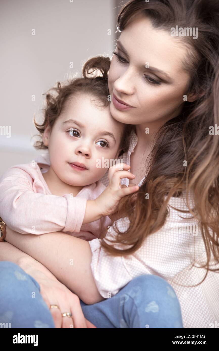 Bonita mamá abrazando a su amada hija Foto de stock