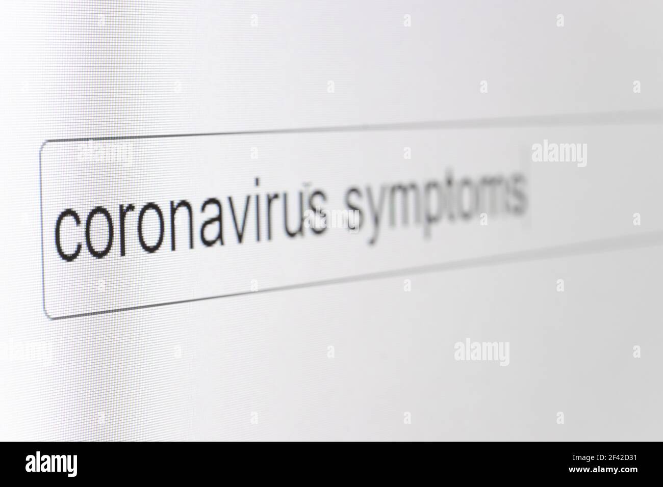 Barra de búsqueda en el monitor de un ordenador con la pregunta síntomas del coronavirus. Buscando información en Internet, en primer plano. Foto de stock
