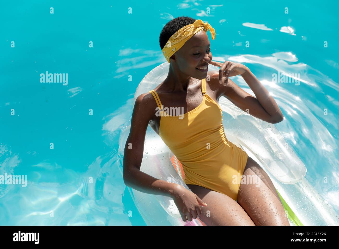 Mujer afroamericana en la piscina tomando el sol en inflable Foto de stock