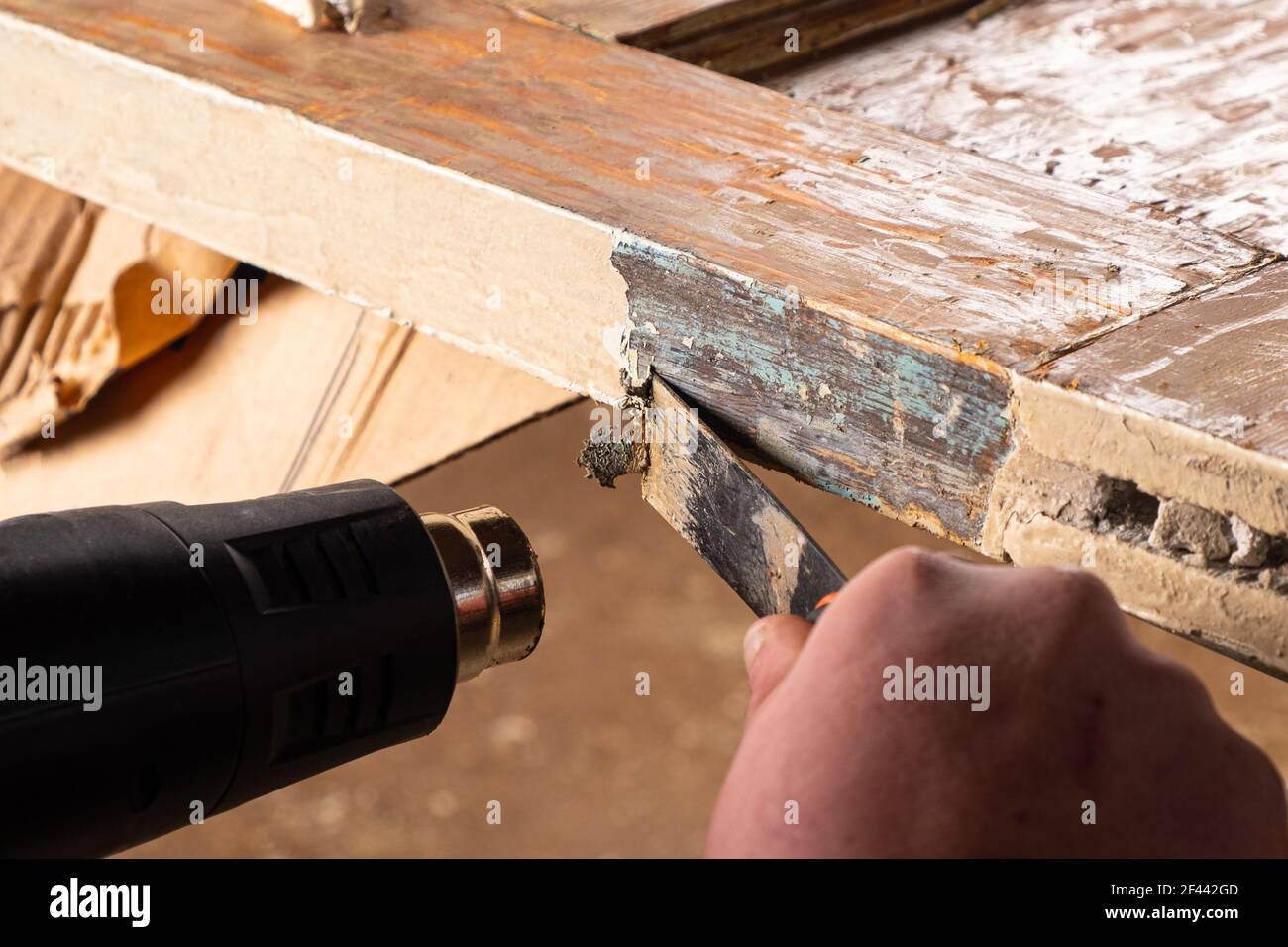 quitar la pintura vieja de las puertas de madera viejas con una espátula y  una pistola de calor, restaurando las superficies de madera viejas  Fotografía de stock - Alamy