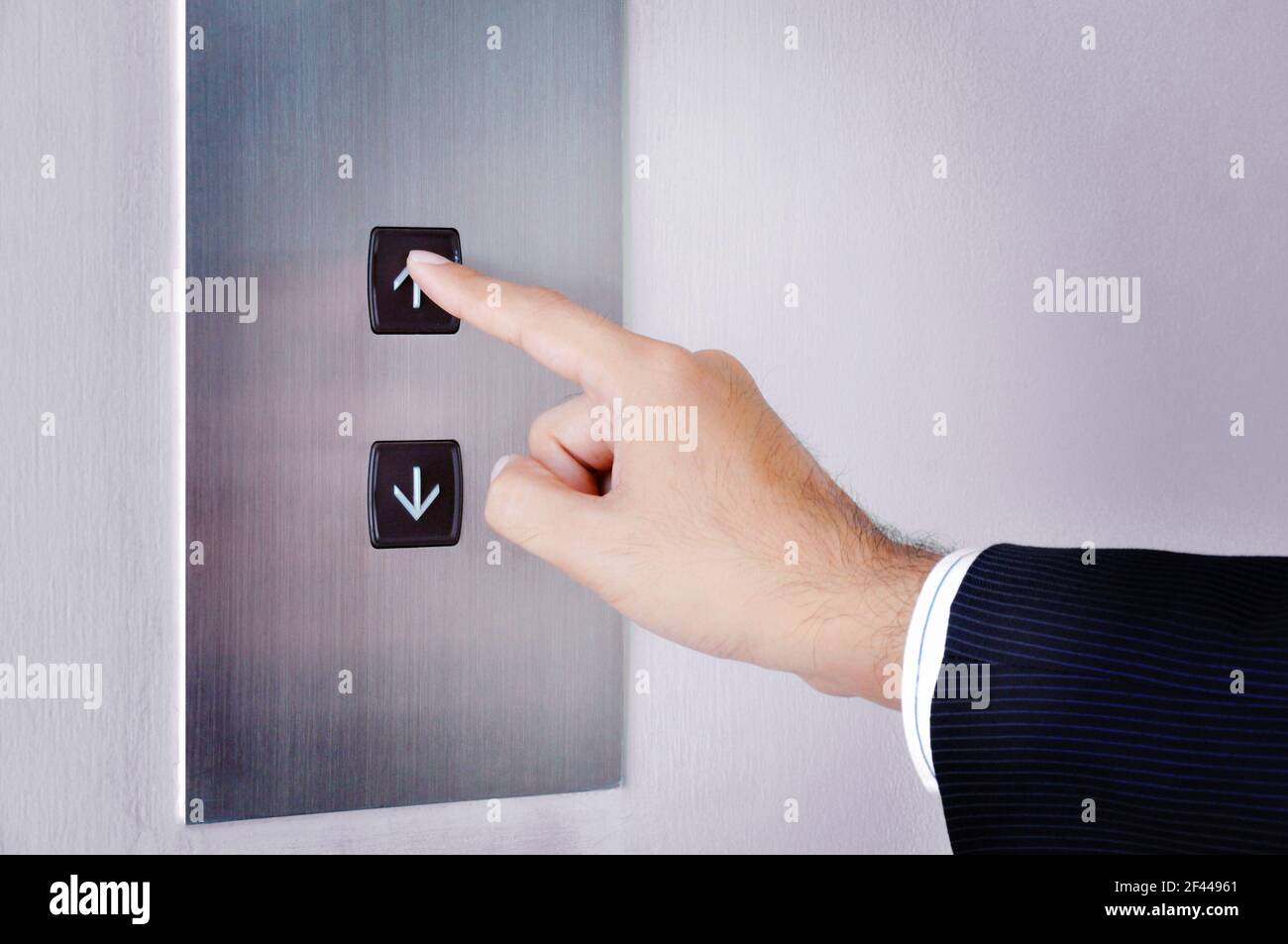 Hombre de negocios pulsando la mano subiendo la señal en el panel de control de elevación Foto de stock