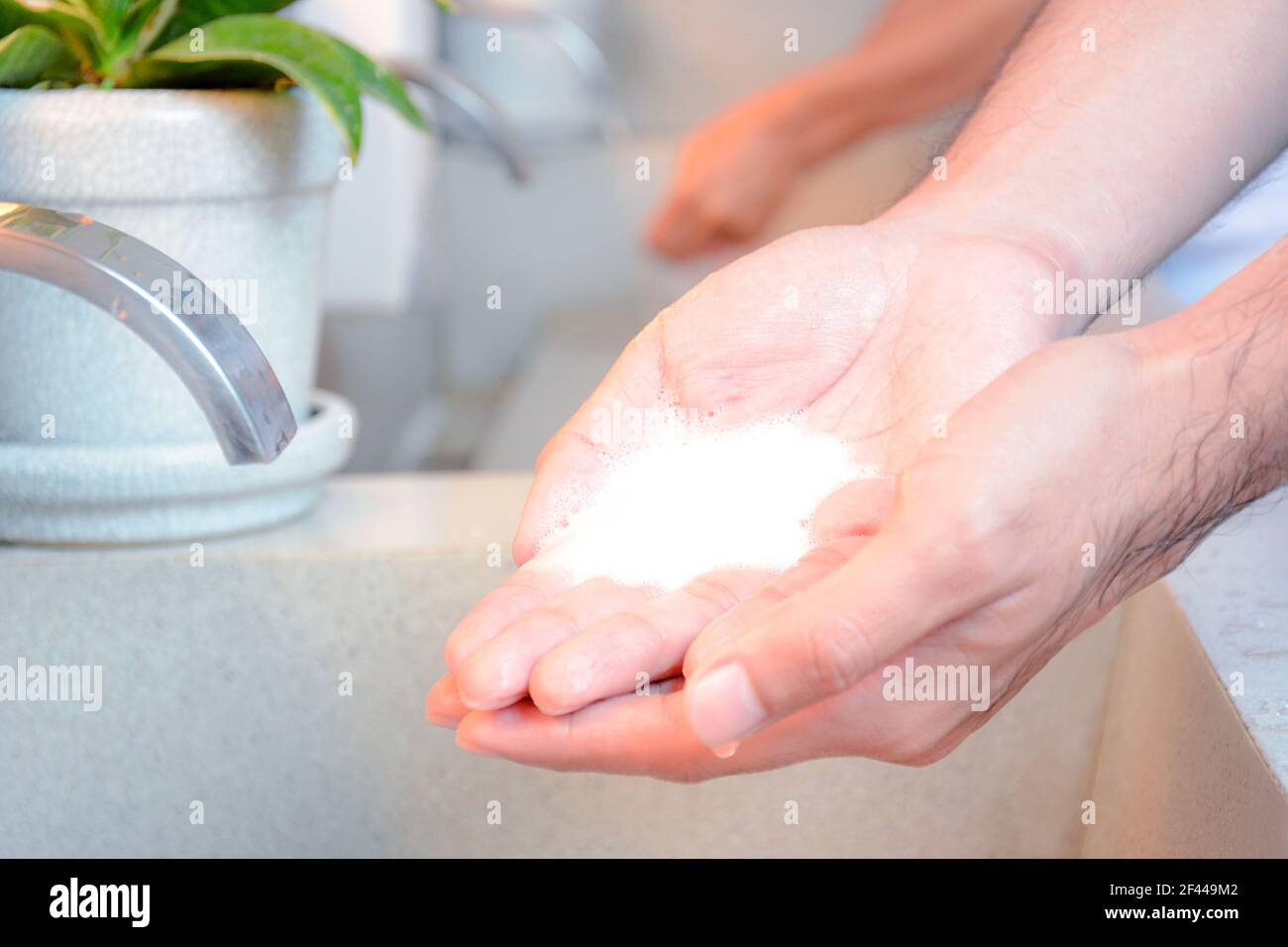 Moje las manos con espuma de jabón a punto de lavarse (con toma de sensor automática) Foto de stock